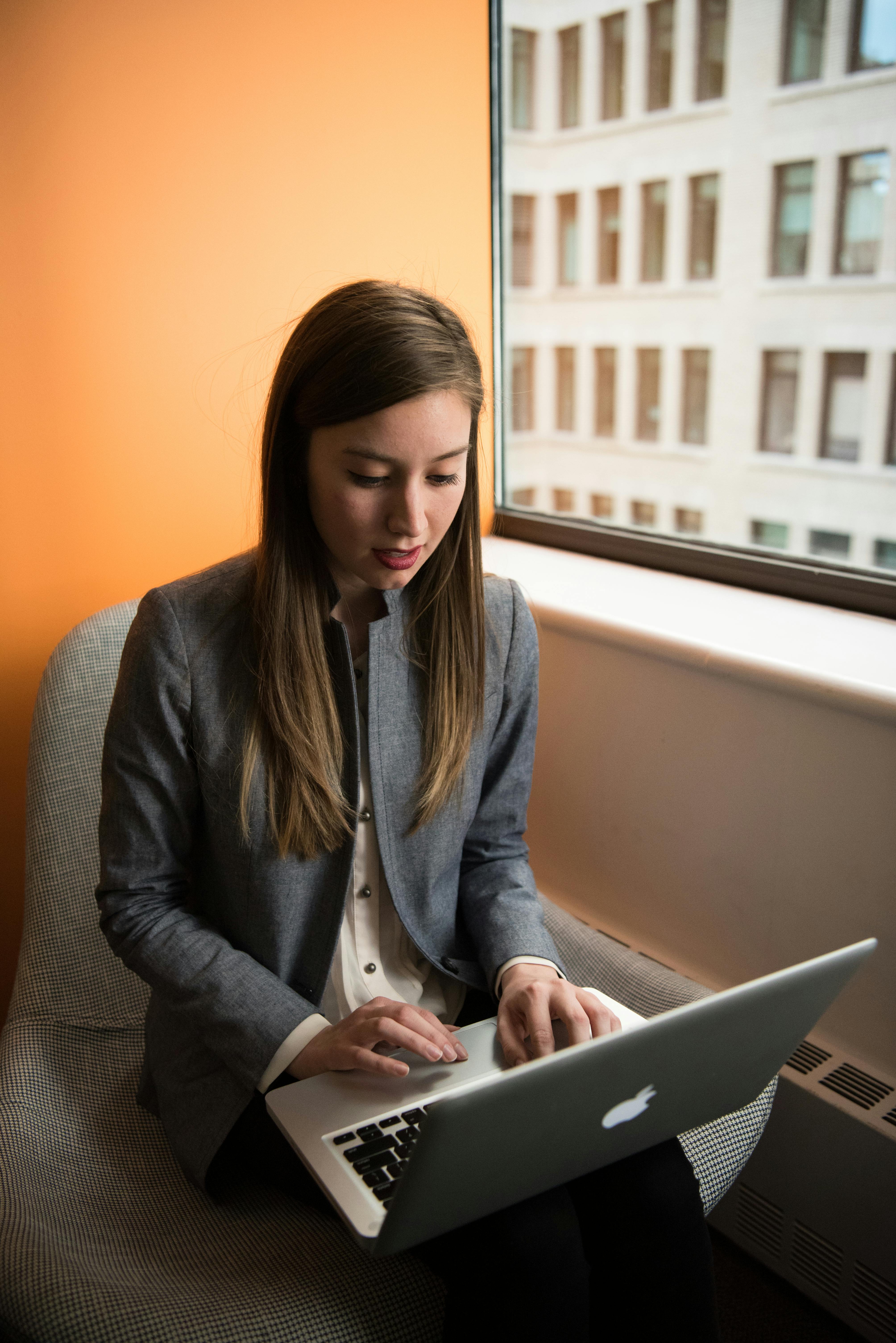 lady sitting behind orange wall